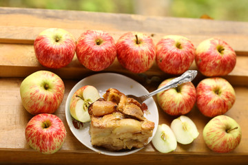 Naklejka na ściany i meble pieces of fresh baked apple pie among raw apples country style still life