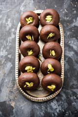 Chocolate Milk peda or pera or pedha made using sweet condensed Milk and cocoa powder, garnished with Pistachio. selective focus