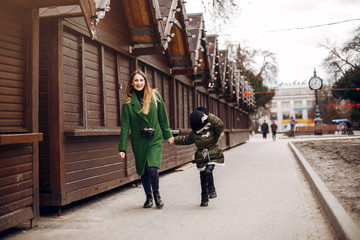 Fashionable mother with daughter. Family in a spring city