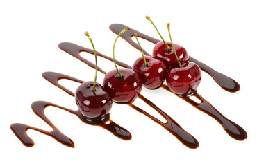 Group of ripe cherries dipped in melted chocolate on a white background