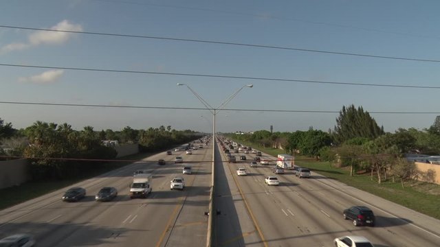 I-95 Facing North through Three Power Lines in Deerfield Beach in a Bright Sunny Late Afternoon in Rush Hour Traffic, Blue Sky with a Few Scattered Clouds