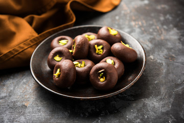 Chocolate Milk peda or pera or pedha made using sweet condensed Milk and cocoa powder, garnished with Pistachio. selective focus