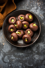 Chocolate Milk peda or pera or pedha made using sweet condensed Milk and cocoa powder, garnished with Pistachio. selective focus