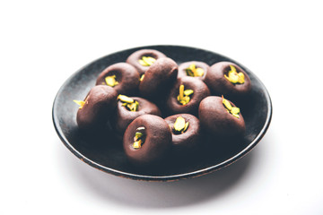 Chocolate Milk peda or pera or pedha made using sweet condensed Milk and cocoa powder, garnished with Pistachio. selective focus