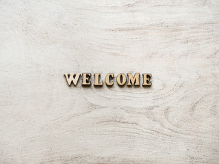 Letters of the alphabet in the form of the word WELCOME on a white board. Top view