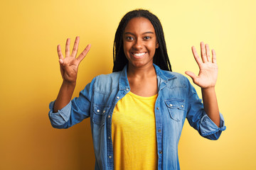 Young african american woman wearing denim shirt standing over isolated yellow background showing...