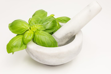 basil leaves with white and grey marble mortar and pestle