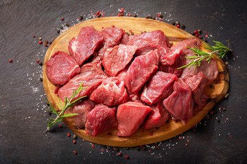 fresh chopped meat with rosemary on wooden board,