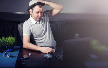 man at table and working on laptop