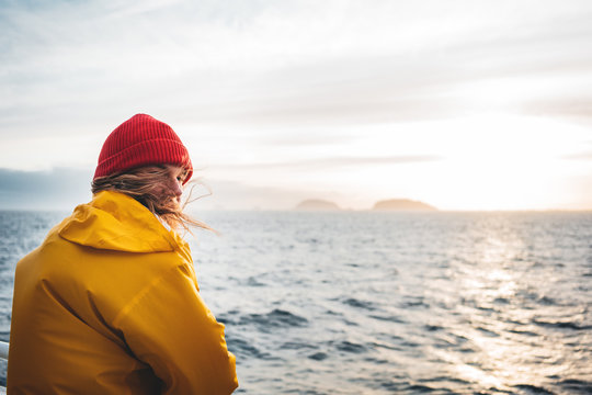 Anone man traveler floating on ship looking at sunset sea after storm and foggy mountains on skyline. Lifestyle travel outdoor scandinavian authentic landscape, wanderlust