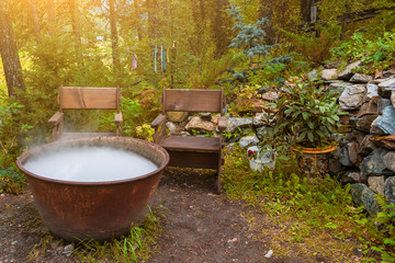 A large pot or pan over a fire while preparing a potion or meal, evaporating a large amount of steam while boiling water on autumn indian summer. Mystical occult worship of the devil with sacrifice.