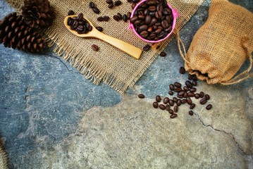 Obraz na płótnie Canvas Roasted coffee beans in a pink zinc bucket on a sackcloth background.