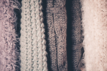 Knitted sweaters hanging in shop closeup. Winter season.