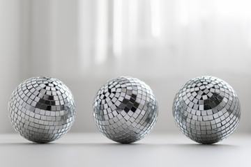 three disco balls on a light background with shadow