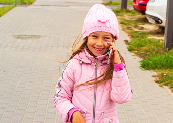little girl playing with mobile phone. new digital technologies in the hands of a child. Portrait of a baby with a smartphone