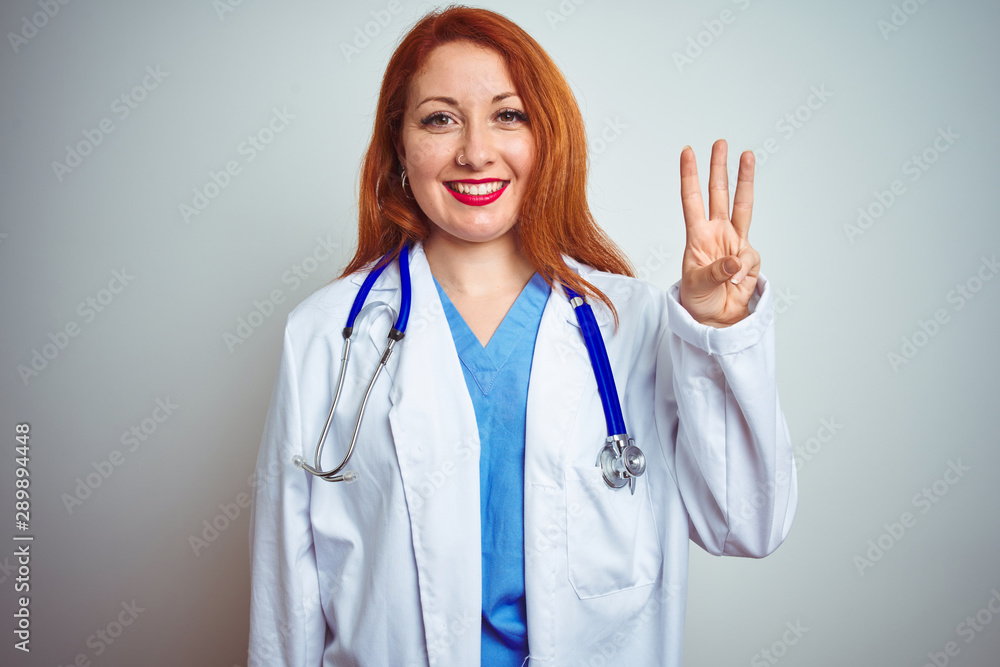 Sticker young redhead doctor woman using stethoscope over white isolated background showing and pointing up 