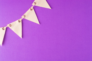 Flag triangular decorativ, party garland over colorful purple background. Christmas party, birthday mockup with copy space.