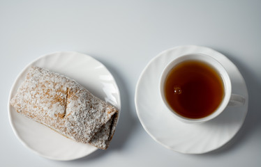 Tea on a saucer with sweet pastries