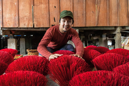 Asian traveler male making the traditional vietnam red insense in old traditional house at long xuyen, an giang province, vietnam,traditional and culture concept