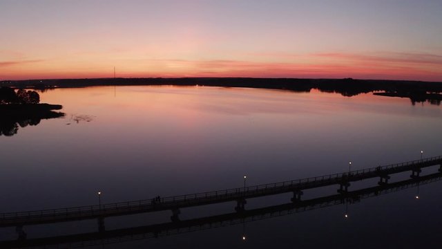 Flight by drone over the bridge of Lake Sirvėna. The wooden pedestrian bridge, the longest in Lithuania, over the artificial lake Sirvėna near Birzai. The bridge is located in Regional Park