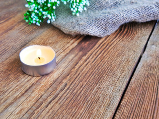 Fired candle on wooden table. Scandinavian minimalism design with copy space. Selective focus.