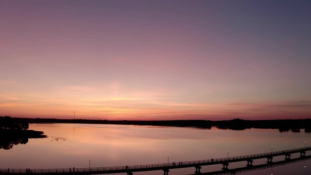 Flight by drone over the bridge of Lake Sirvėna. The wooden pedestrian bridge, the longest in Lithuania, over the artificial lake Sirvėna near Birzai. The bridge is located in Regional Park