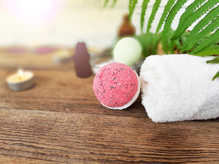 Pink bath bomb with towel  on wooden background. Summer spa life style concept for vacation and...