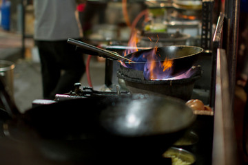 The chef heats up the oil in the wok ready for cooking
