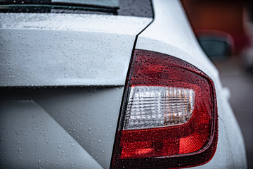 view of the rear of a white car with water drops after rain. Concept on the topic of polishing a car. 