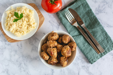 Pork meatballs in tomato sauce served with couscous