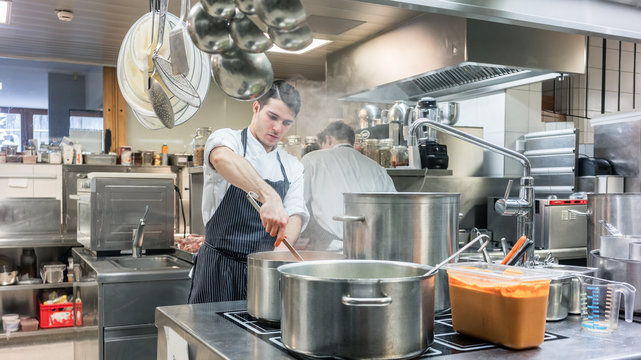 Portrait of a dedicated young head chef cooking in the commercial kitchen of a hotel