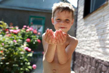 Fototapeta premium Child catches drops of water with hands