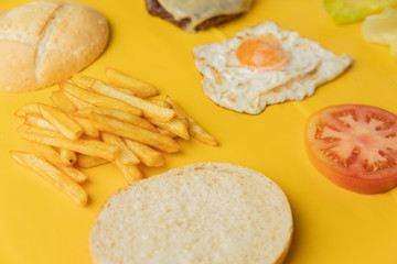 Ingredients for making hamburger on yellow background
