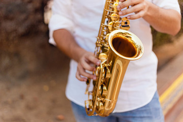 Close up of a man passionately playing the saxophone at the street