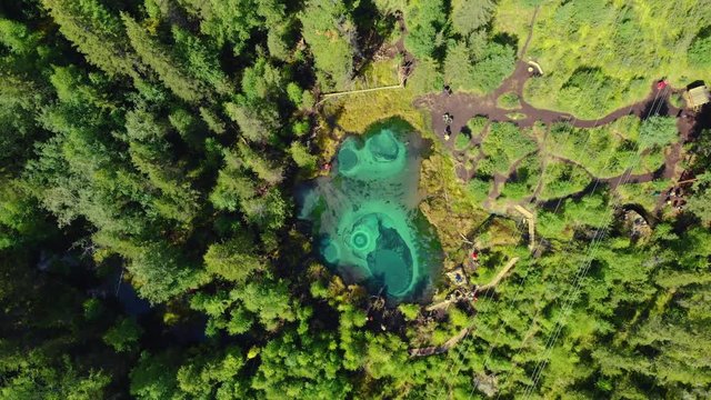Beautiful Geyser lake with thermal springs that periodically throw blue clay and silt from the ground. Aerial drone view. Aktash, Altai mountains, Russia