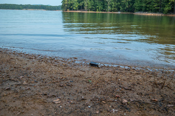 Fototapeta na wymiar Can left on the beach at the lake