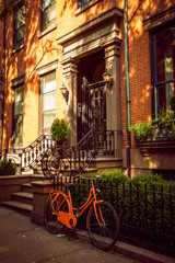 Orange Bicycle in front of Brooklyn residential house in Brooklyn Heights district