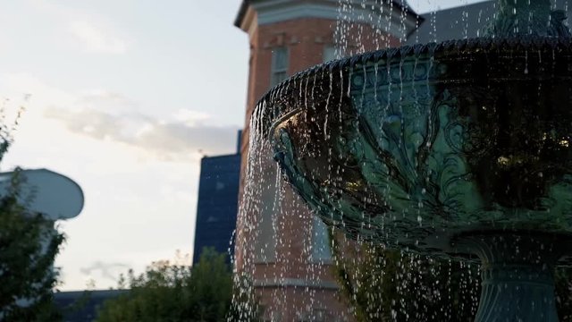Gorgeous green copper fountain in slow motion on a bright sunny summer day