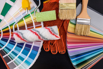 Roller and brushes with color swatch on dark table