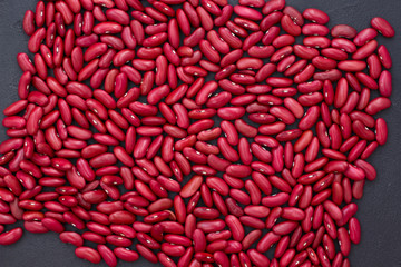 Red beans on a black background, top view.