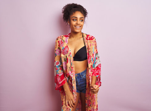Young beautiful african american woman on vacation standing wearing bikini and colorful caftan