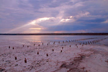 Sunbeam illuminated salty estuary at sunset.