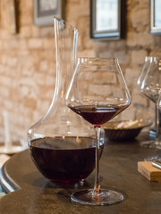 Glasses of red wine are on the bar.