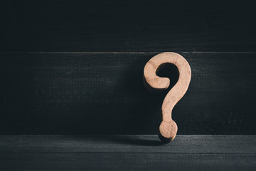 Wooden question mark on wood table background. Problem solving concept.