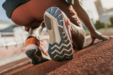 Close up of runner in starting position. Focus on sneakers