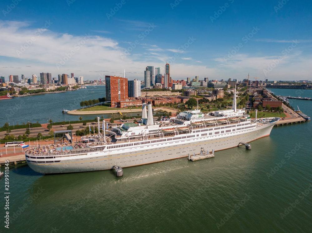 Wall mural aerial of ss rotterdam ship moared on katendrecht land head with skyline of towers and erasmus bridg