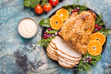 Roasted turkey breast for festive dinner on dark stone background, top view with copy space