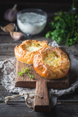 Fresh homemade open patties with cheese. Traditional Russian yeast pastry, round buns, curd tart. Buns with cottage cheese. Rustic style. Wooden background