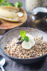 Healthy breakfast bowl. Granola with chocolate and banana on white wooden table. The concept of healthy nutrition and diet.