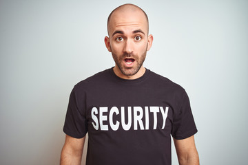 Young safeguard man wearing security uniform over isolated background afraid and shocked with...